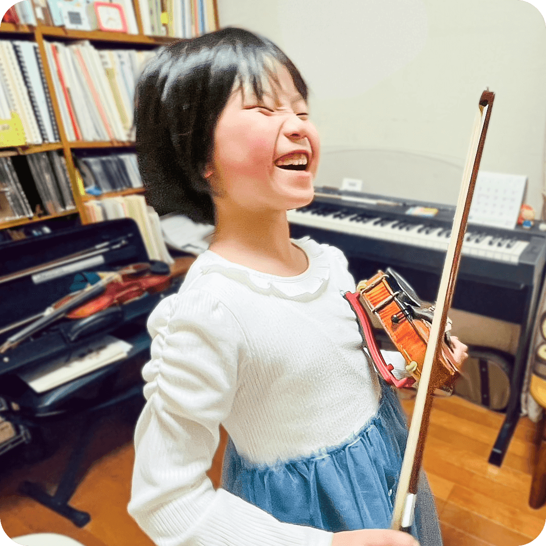 バイオリンを持って笑う女の子の写真