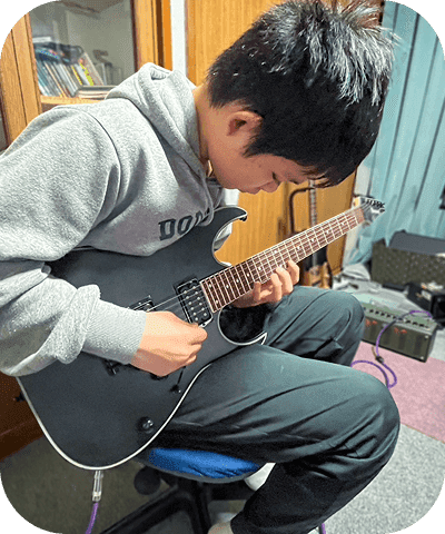 真剣にエレキギターを弾く男の子
