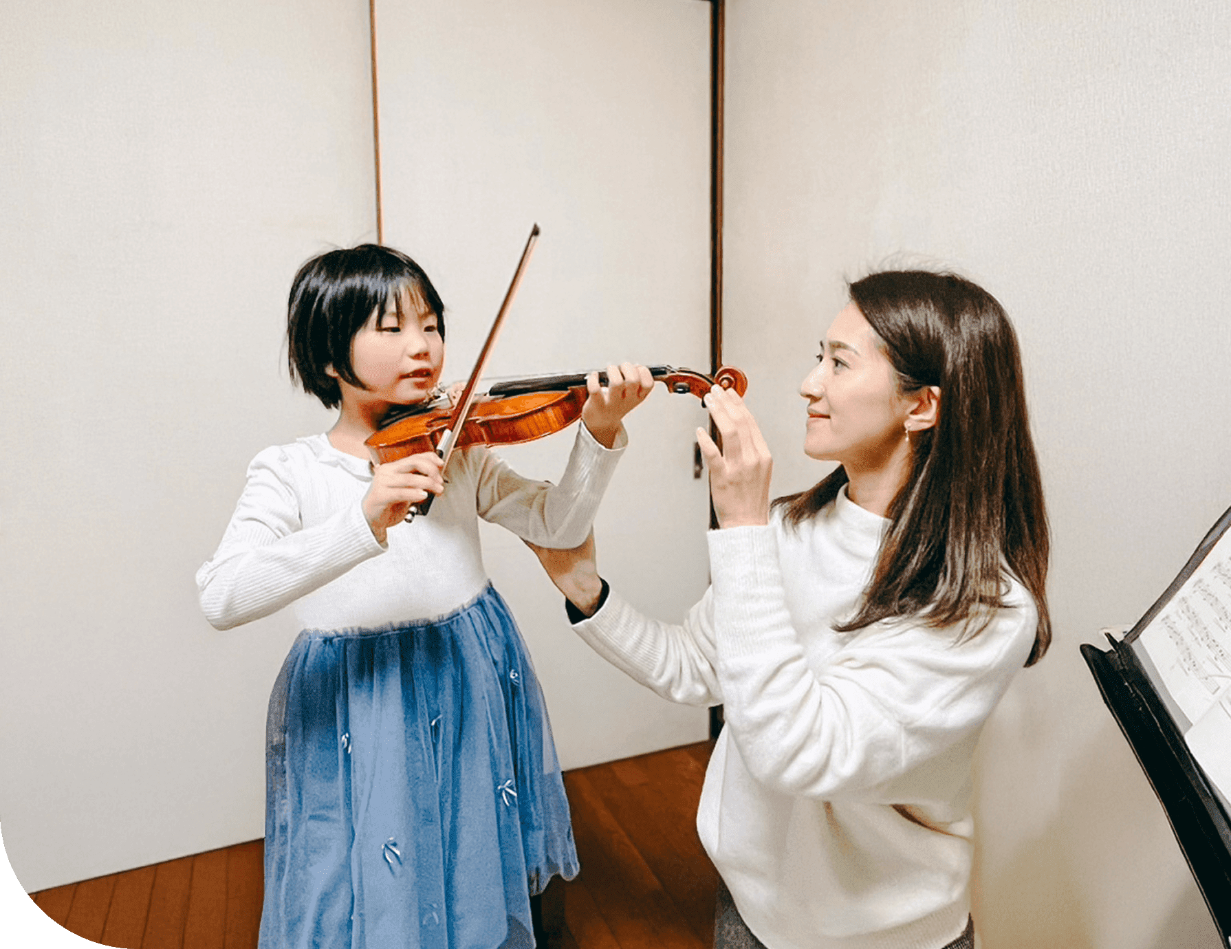 バイオリンを持った女の子と講師の写真
